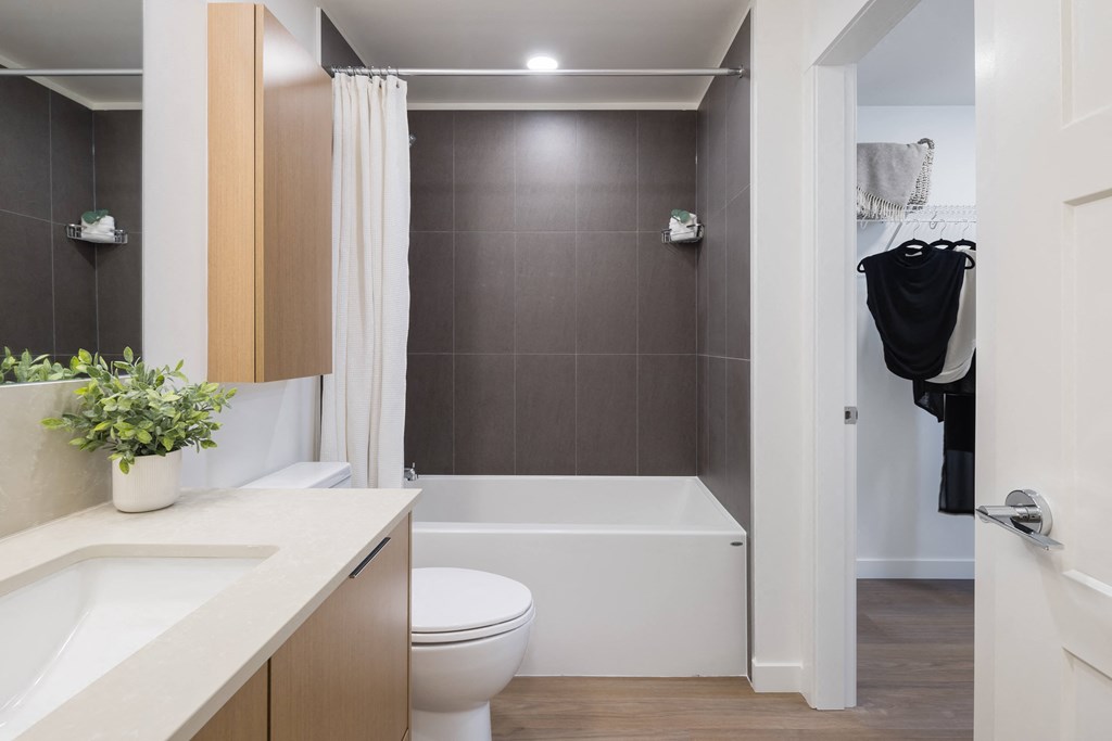 A bathroom with a white toilet and a white bathtub.