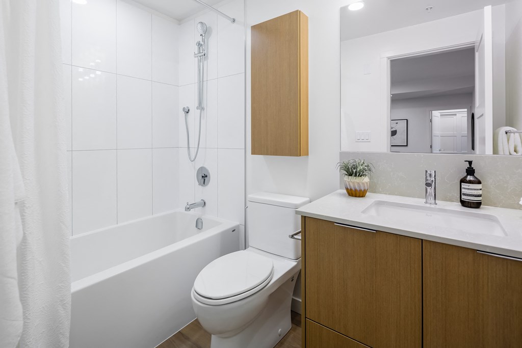 A white toilet sits next to a white sink in a bathroom.