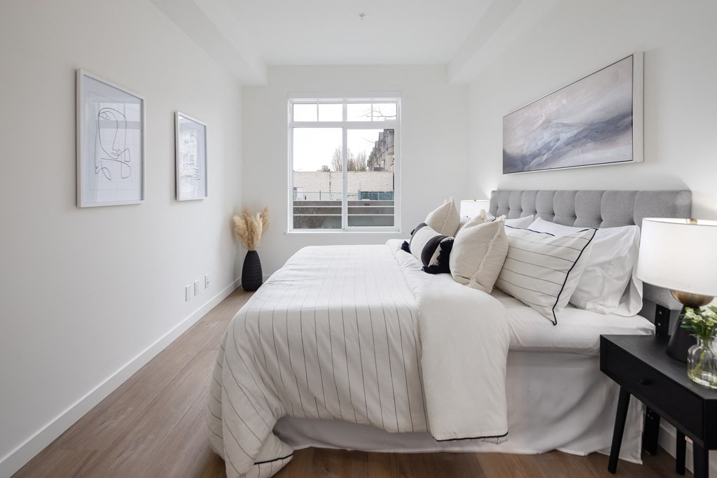 A bedroom with a large bed and a window overlooking a parking lot.