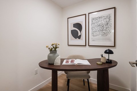 a small table in a room with two pictures on the wall