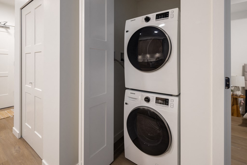 Two white front loading washing machines in a laundry room.