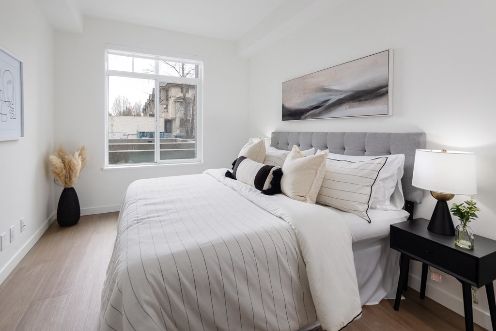 A bedroom with a large bed and a painting on the wall.