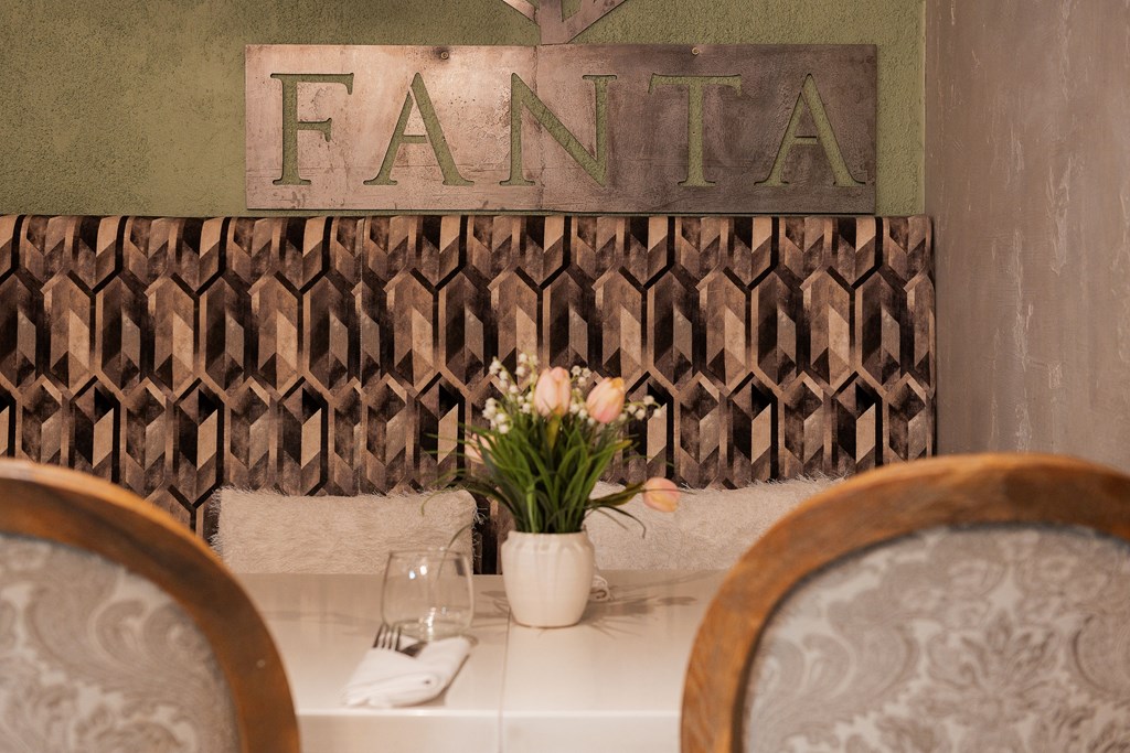 A dining table with a vase of flowers and a sign that says "FANTA".