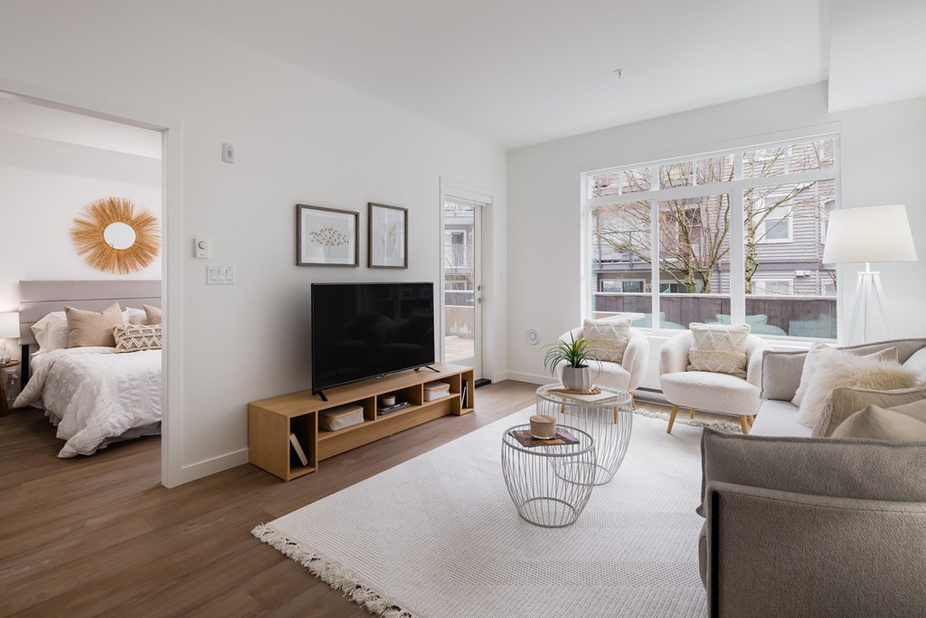 A modern living room with a flat screen TV and a large window.