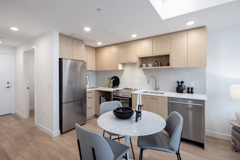 a kitchen with stainless steel appliances and a table and chairs