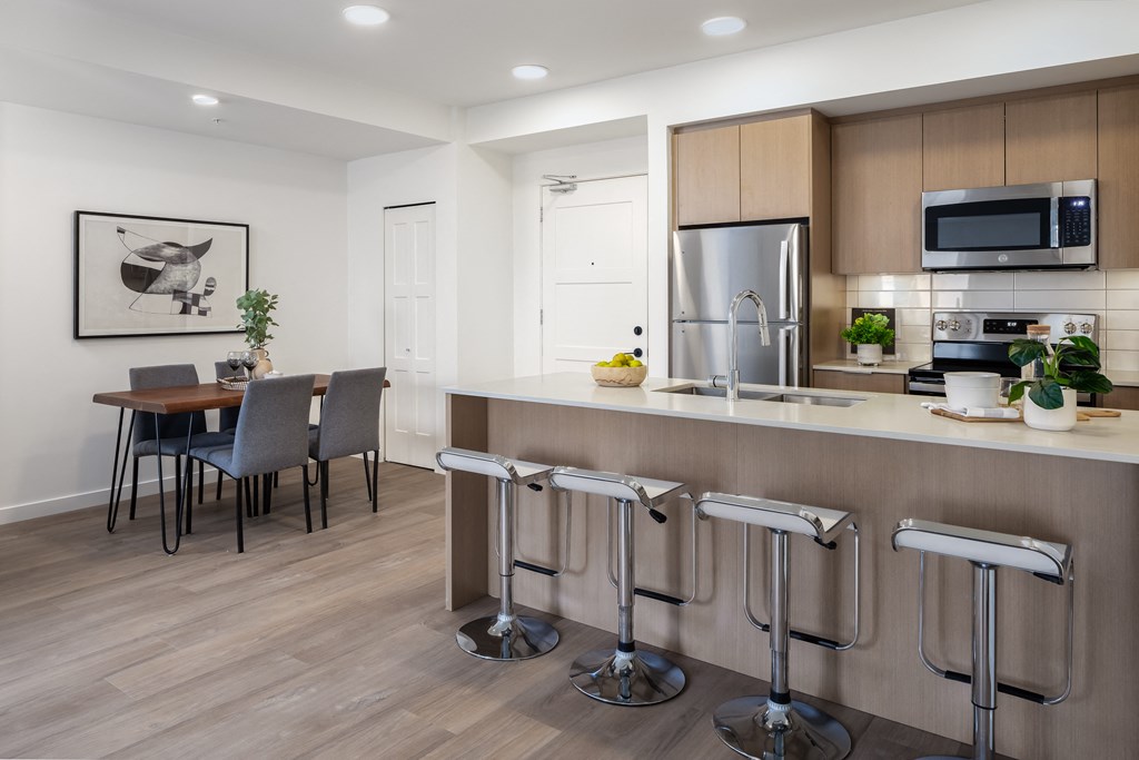 A modern kitchen with a bar stool in front of it.