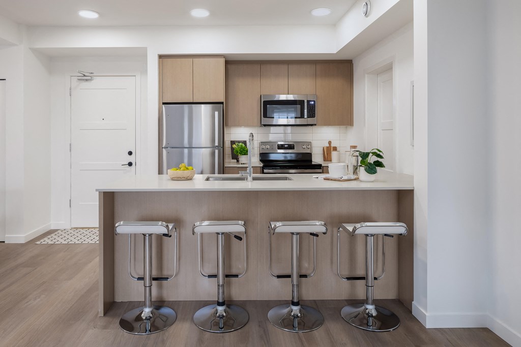 A kitchen with a bar stool in front of it.
