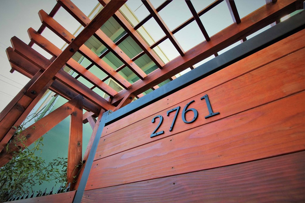 a close up of a wooden gate with a house number on it