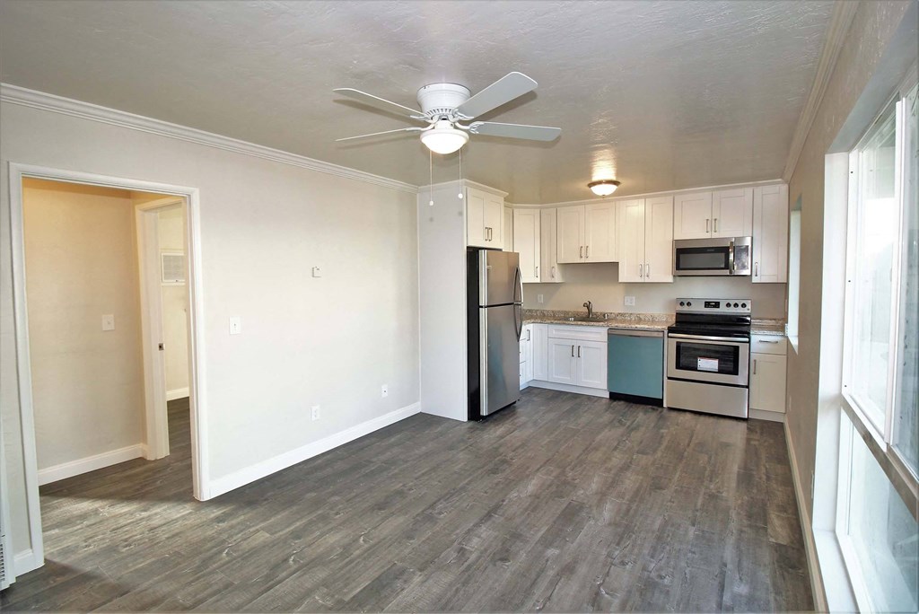 an empty kitchen with a ceiling fan and