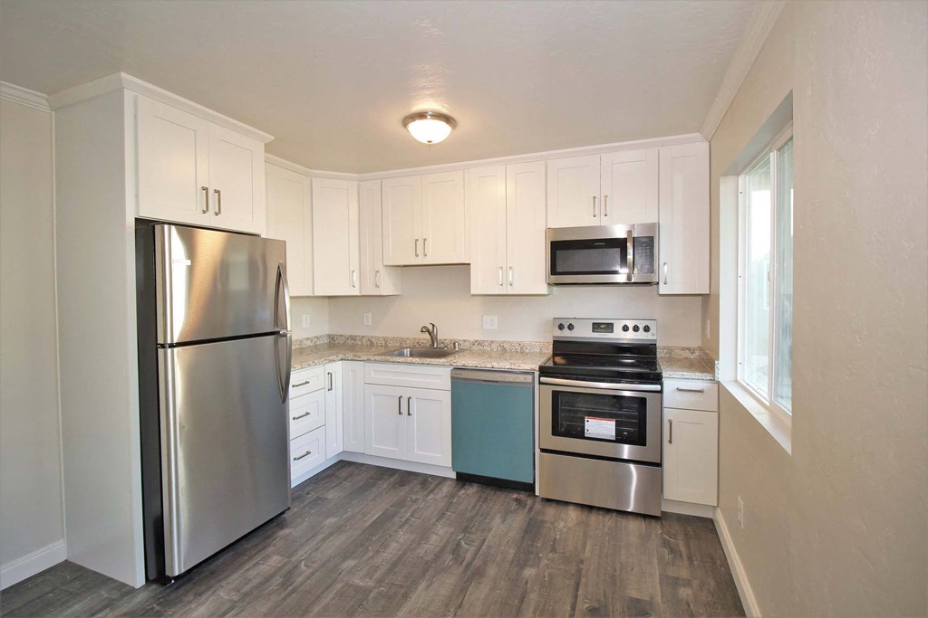 a kitchen with white cabinets and stainless steel appliances