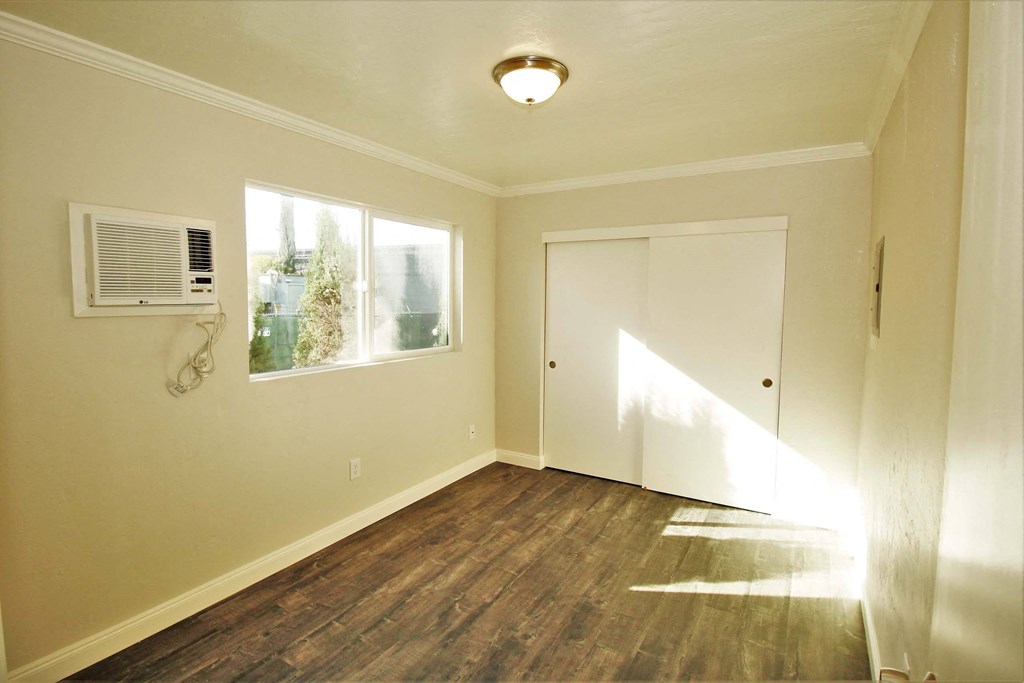 an empty room with a door and a window and a air conditioner