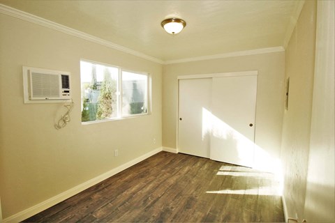 an empty room with a door and a window and a air conditioner