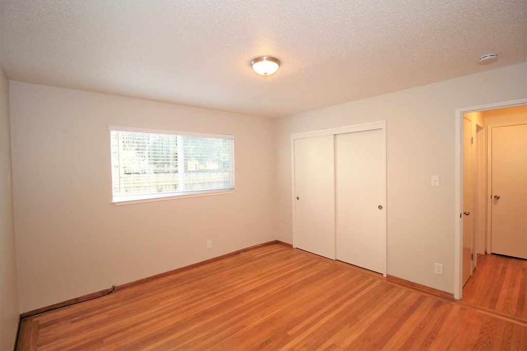 a living room with a hard wood floor and a window