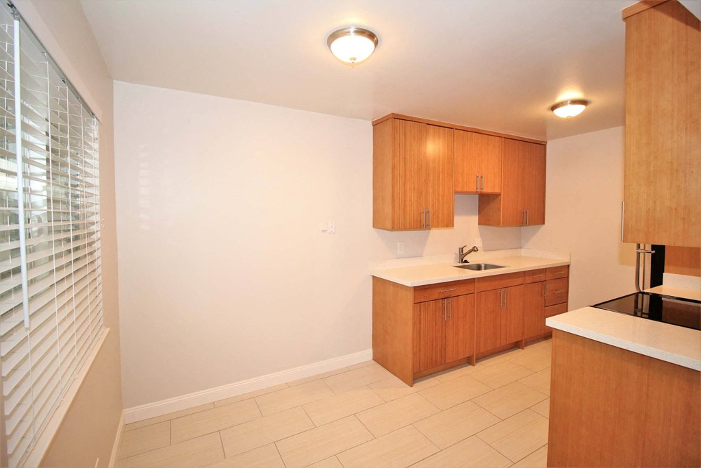 a kitchen with wooden cabinets and a sink and a window