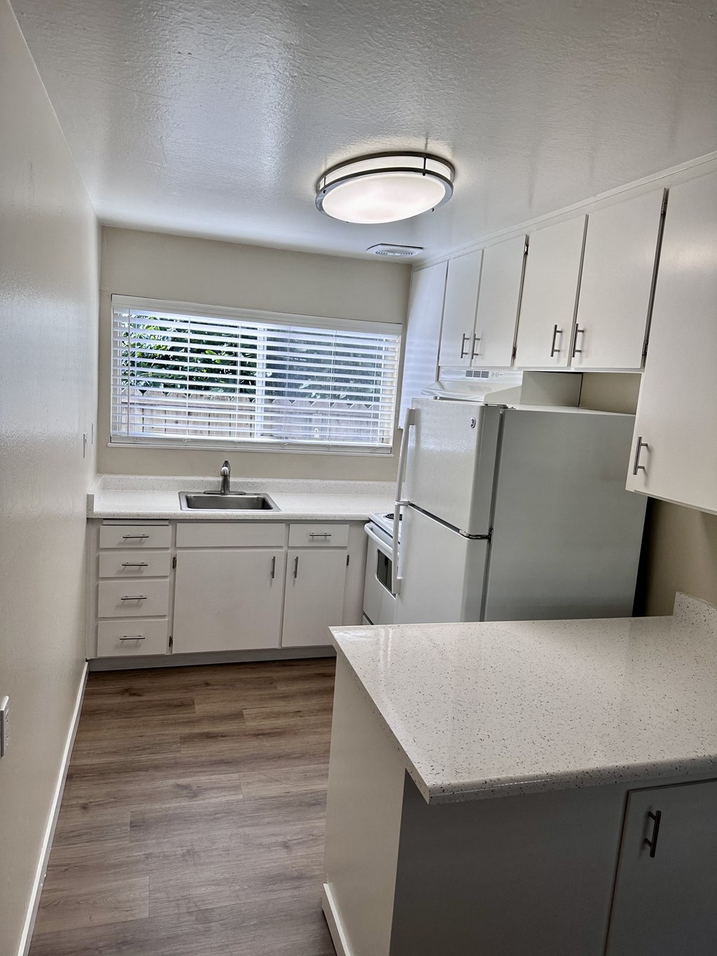 an empty kitchen with white cabinets and stainless steel appliances