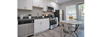 a kitchen with stainless steel appliances and a table with chairs