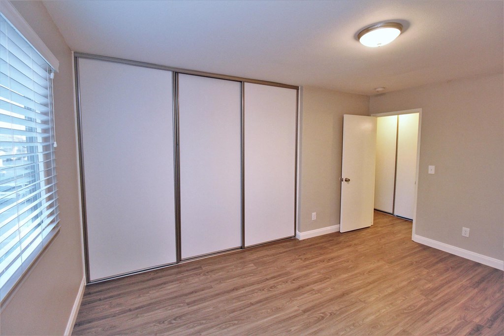 an empty room with white closets and a window
