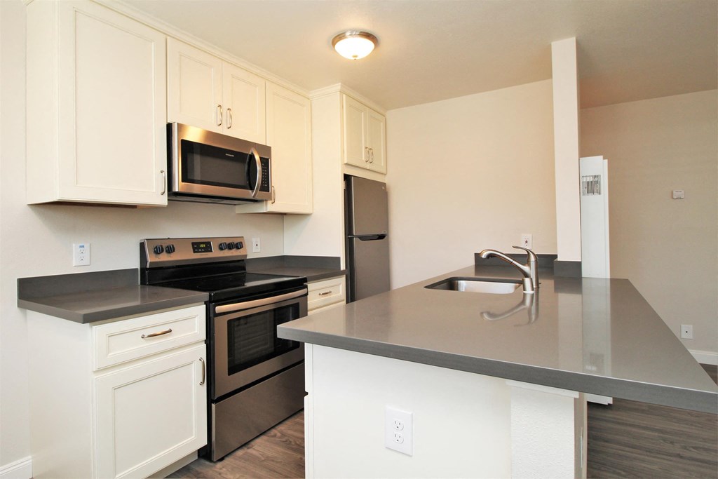 a kitchen with white cabinets and black appliances