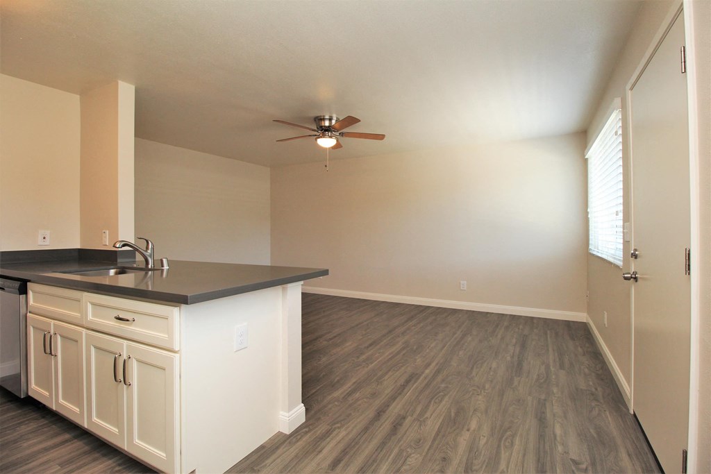 an empty kitchen and living room with a ceiling fan