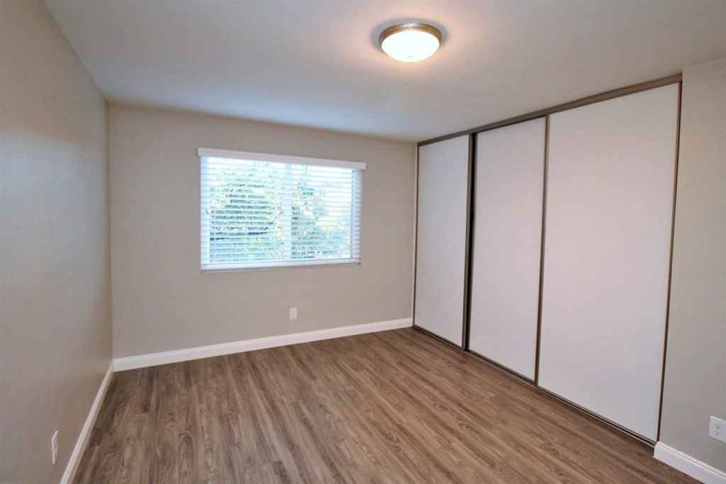 an empty room with white closets and a window