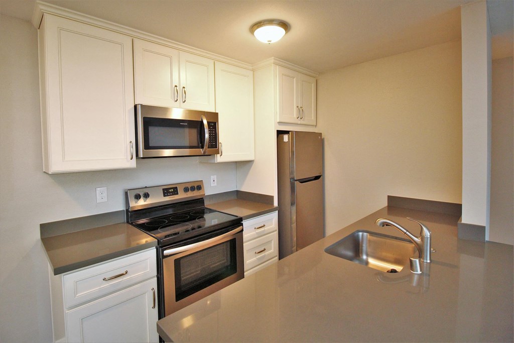 a kitchen with stainless steel appliances and white cabinets