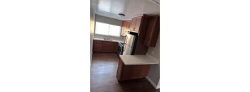 a kitchen with wooden cabinets and a stainless steel refrigerator