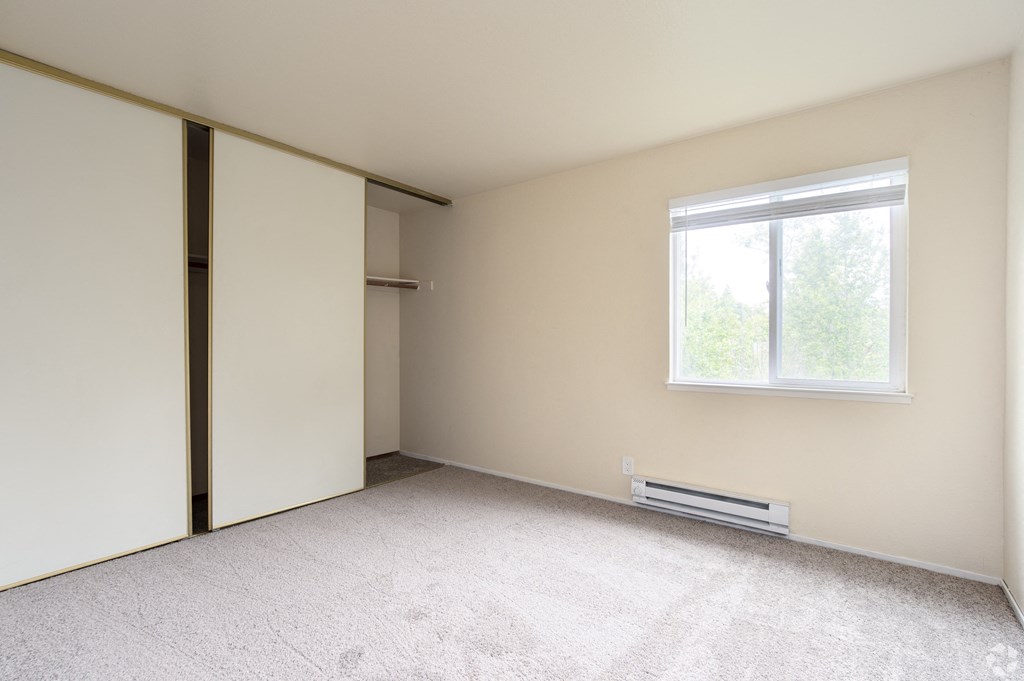 an empty room with white walls and a window
