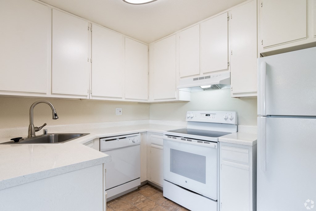 a white kitchen with white appliances and white cabinets