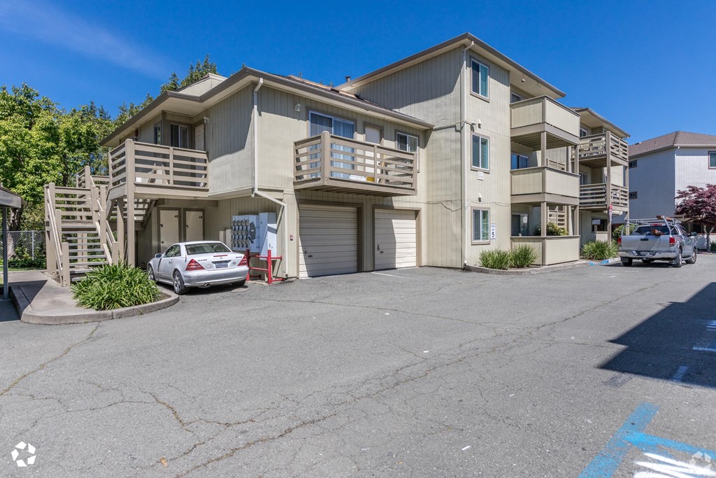an apartment building with two cars parked in front of it