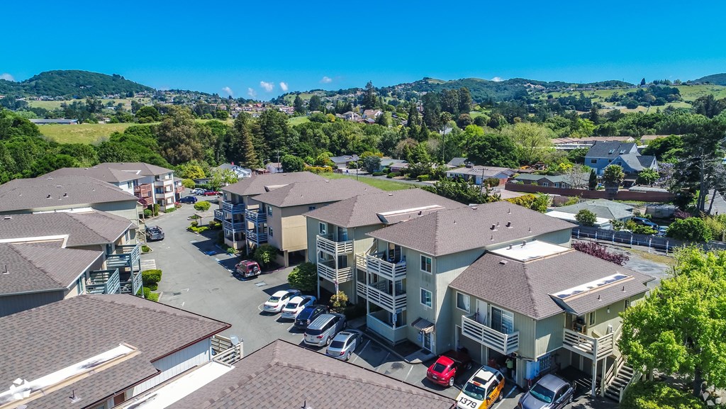 an aerial view of houses with cars parked in front of them
