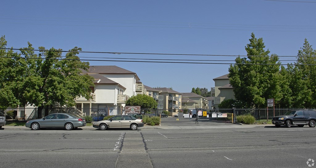 a city street with cars parked in front of houses