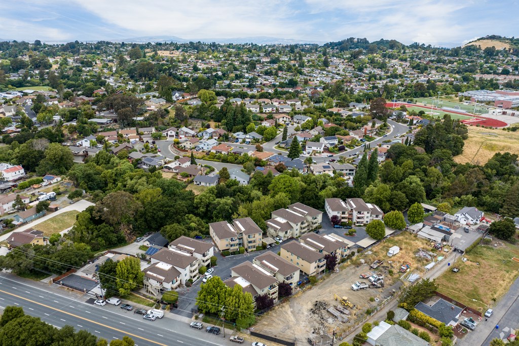 an aerial view of a neighborhood of houses and cars on a road