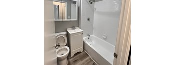 a bathroom with a tub and a toilet and a sink