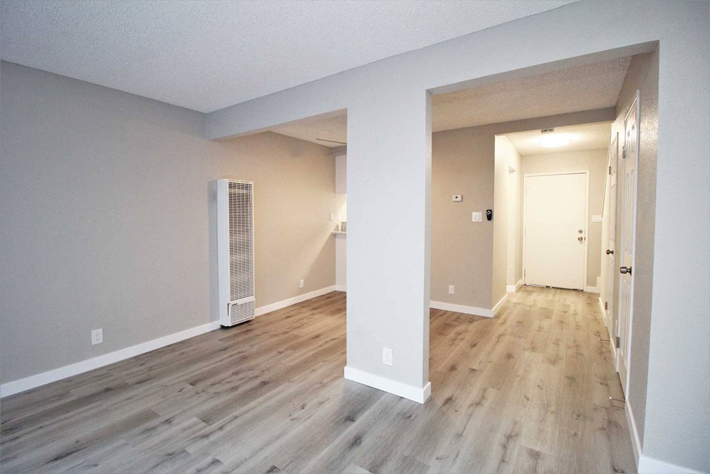 the living room of an empty house with wood flooring