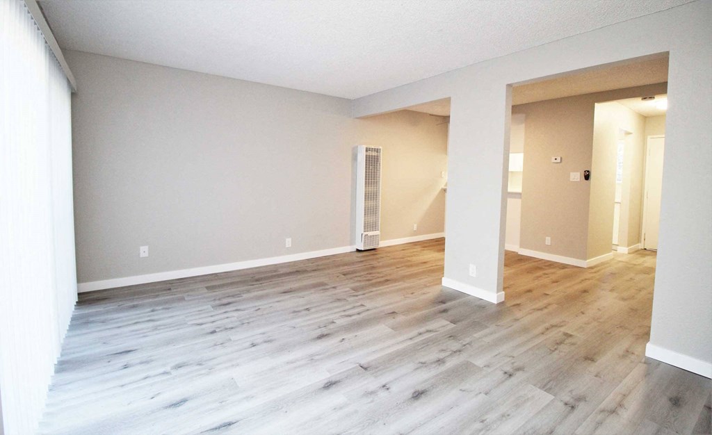 the living room of an empty house with wood flooring