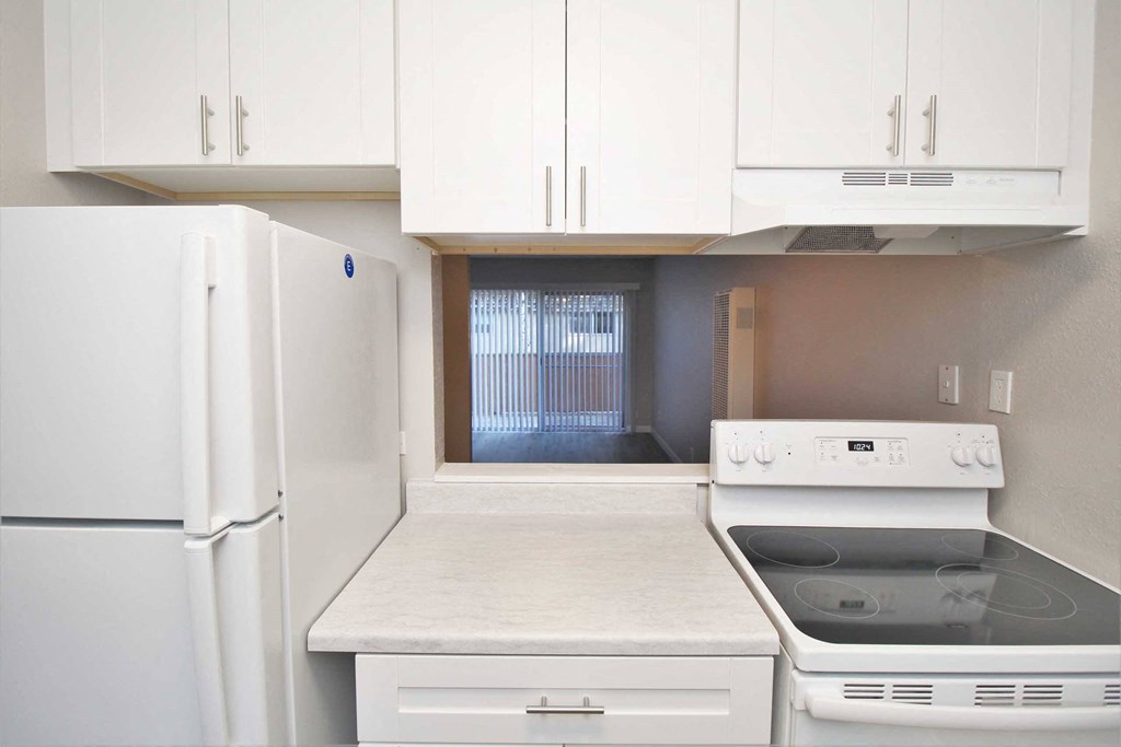 a kitchen with white appliances and white cabinets