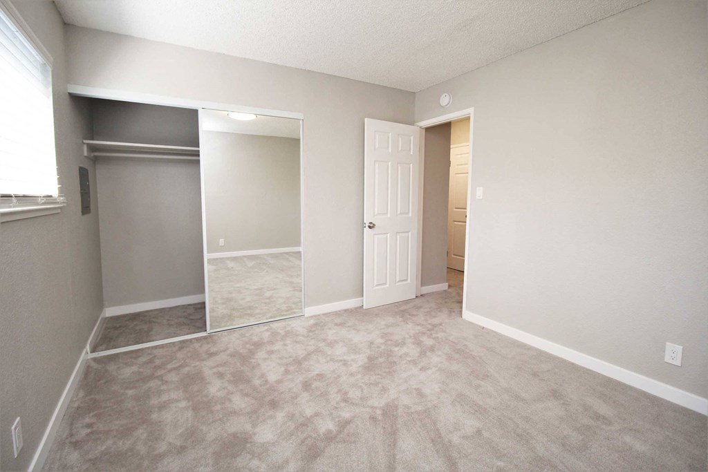 an empty living room with a closet and a door