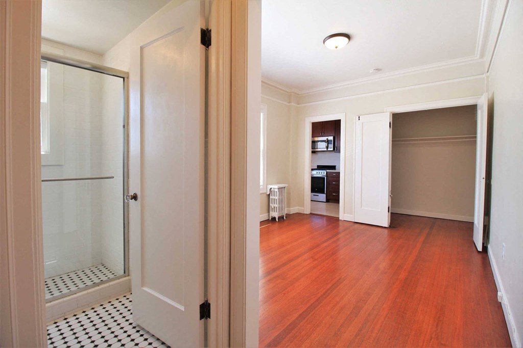 a renovated living room with a glass closet and a wood floor