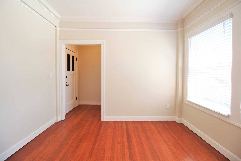 a living room with a hard wood floor and a large window