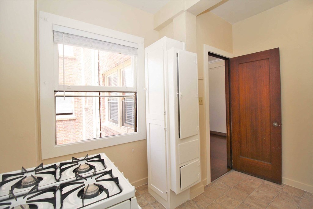 a kitchen with a stove and a door to a closet