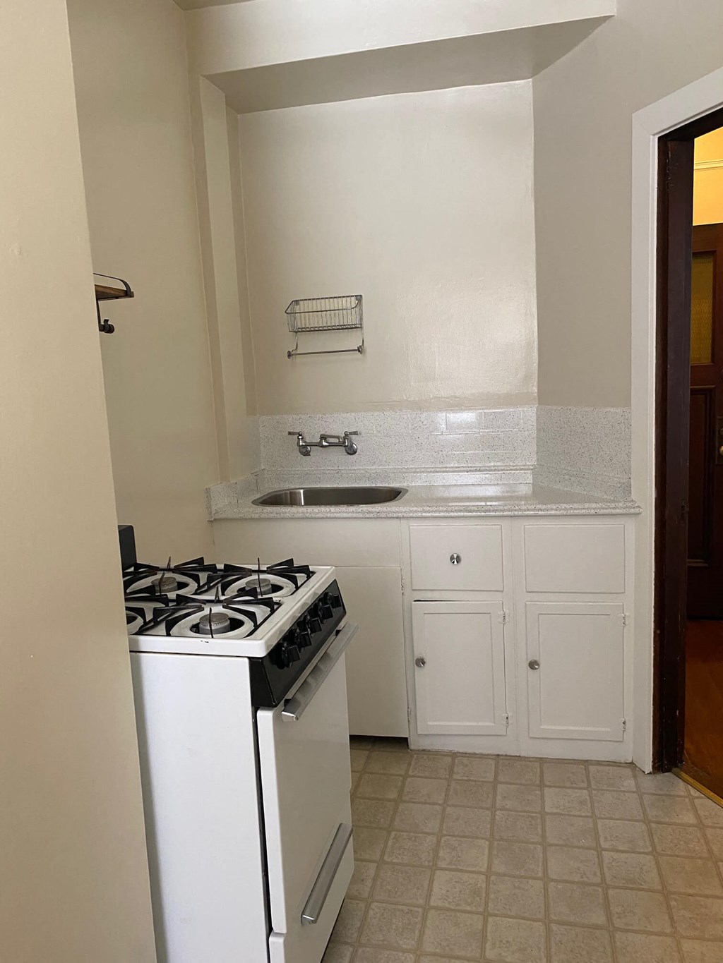an empty kitchen with a stove and a sink
