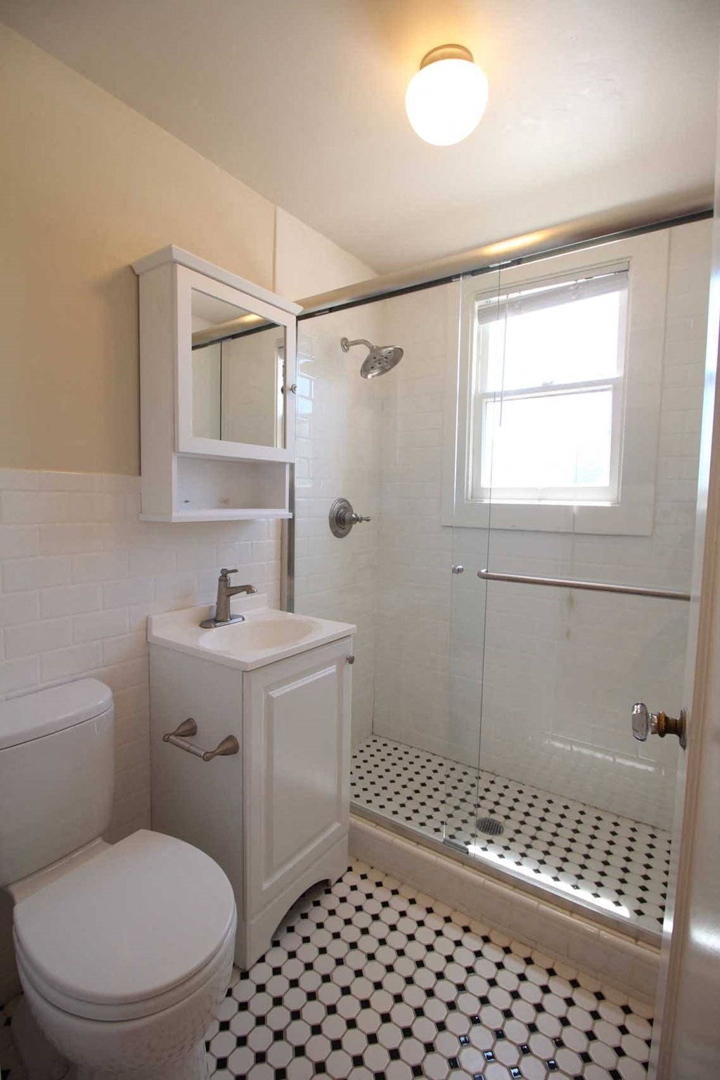 a bathroom with a toilet and a sink and a shower