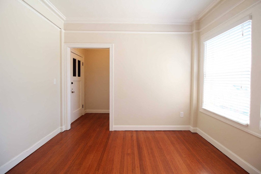 a living room with a hard wood floor and a large window