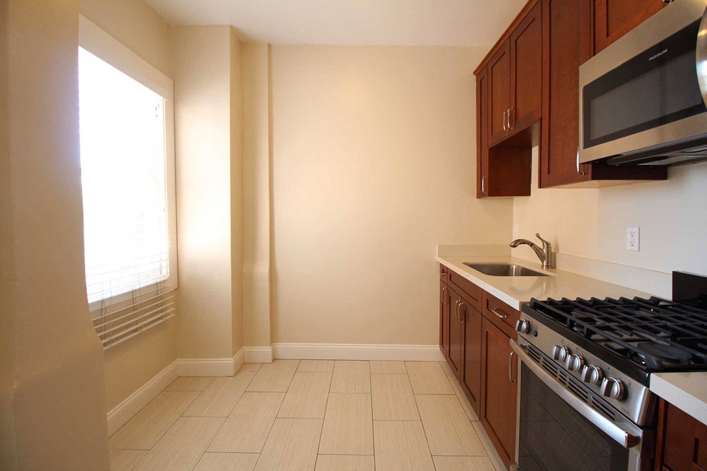 a kitchen with a stove and a microwave and a window