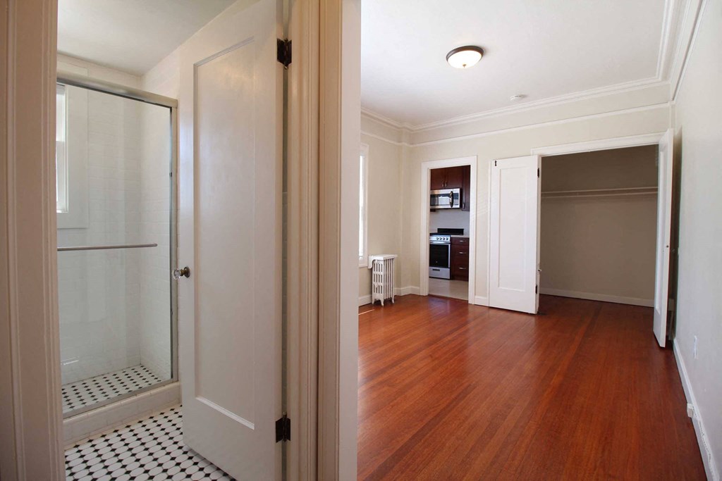 a renovated living room with a glass closet and a wood floor