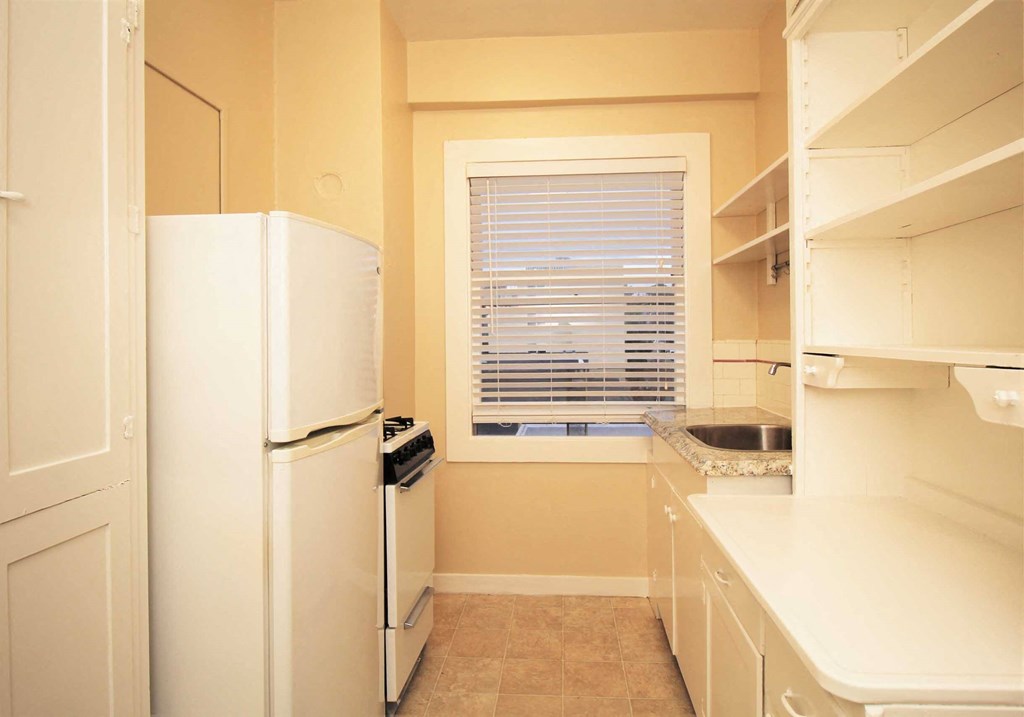 a kitchen with a window and a refrigerator and a sink