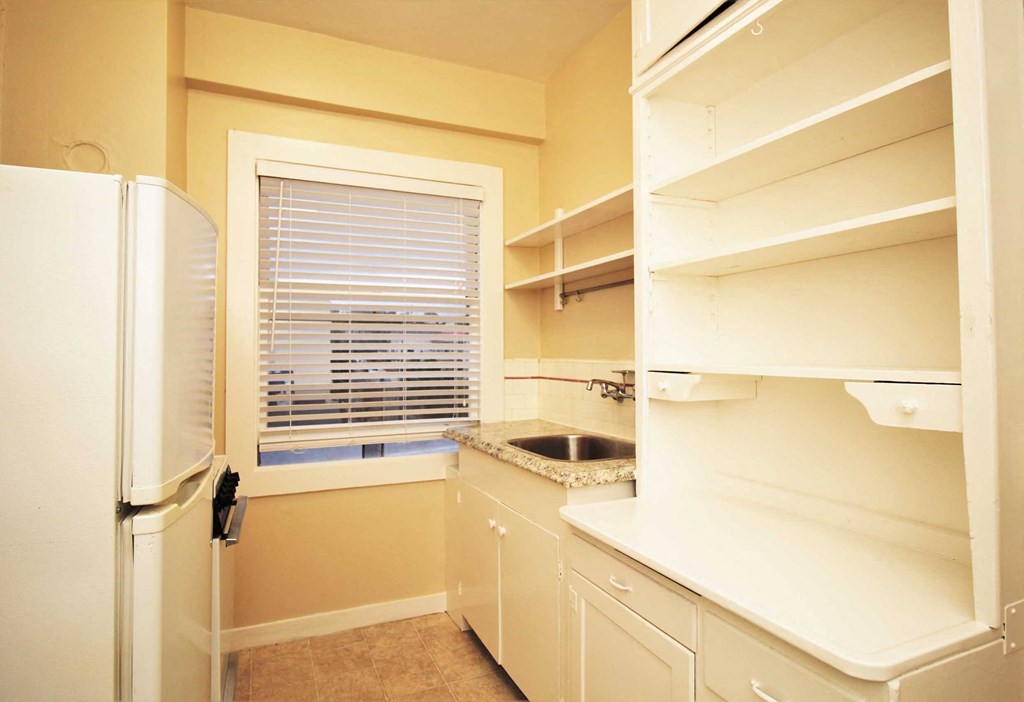 a kitchen with a window and a sink and a refrigerator