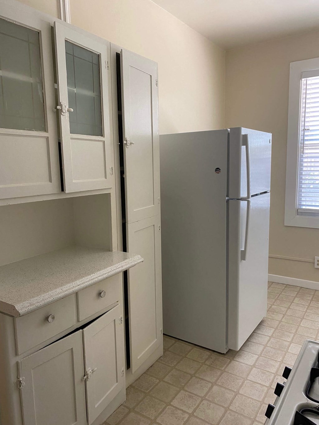 a kitchen with a refrigerator and white cabinets