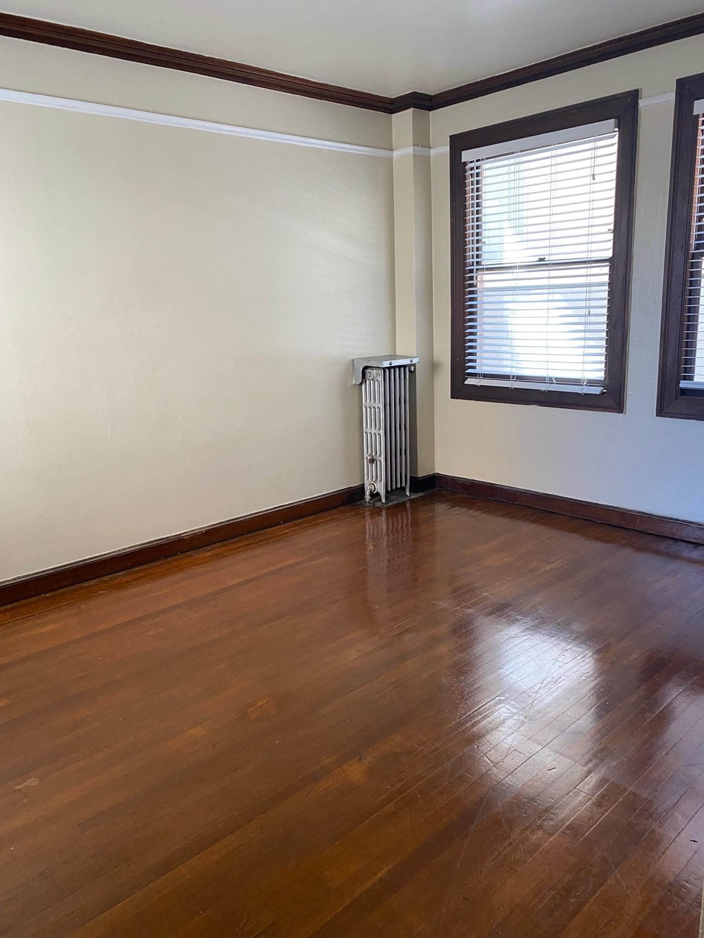 an empty living room with wood floors and a window