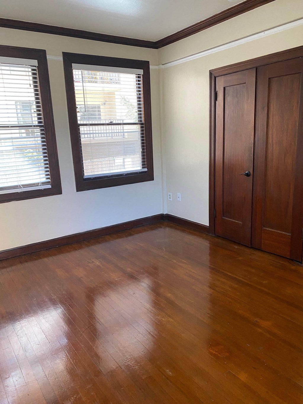 a living room with a hard wood floor and two windows